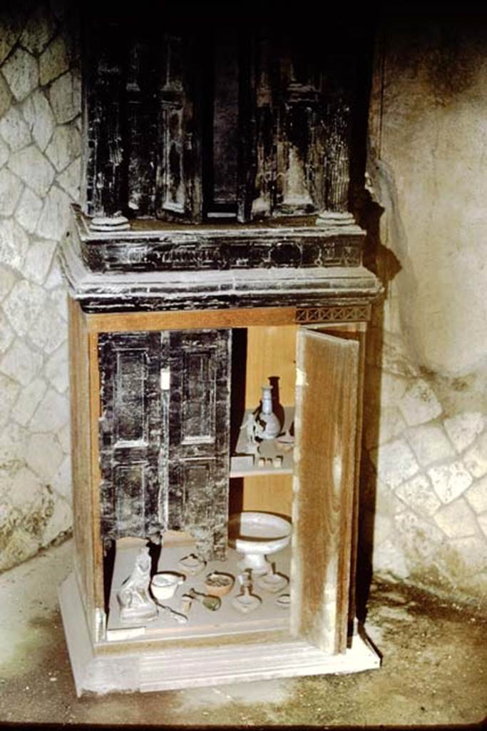 Ins.V.31, Herculaneum, 1961. Wooden lararium with marble capitals with wooden cupboard below. Photo by Stanley A. Jashemski.
Source: The Wilhelmina and Stanley A. Jashemski archive in the University of Maryland Library, Special Collections (See collection page) and made available under the Creative Commons Attribution-Non Commercial License v.4. See Licence and use details. J61f0592